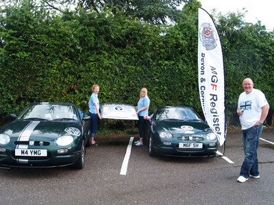 Dora and Jo transferring the Hard Top between cars whilst Steve watches on.